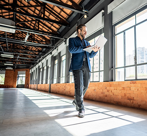 Business person standing in an empty warehouse.