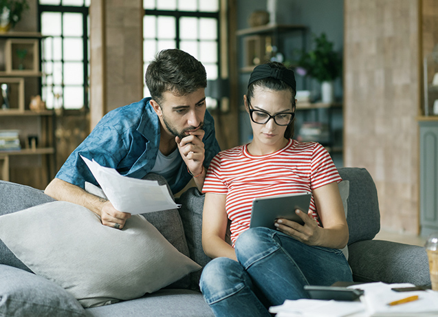 Couple looking a a tablet and financial information.