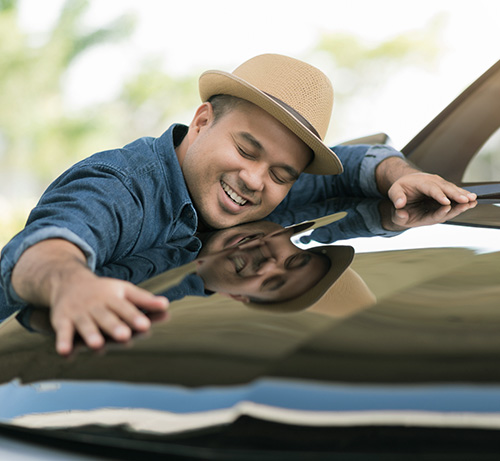 Person hugging their new car.
