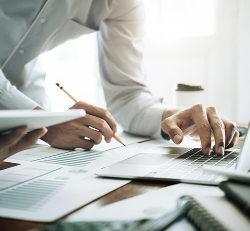 Person using laptop and financials.