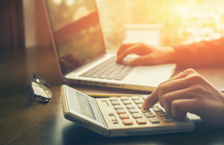 Person using a laptop and calculator.