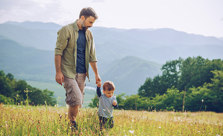 Father and son hiking in a field.