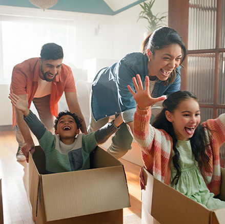 Family playing with boxes in their new house.